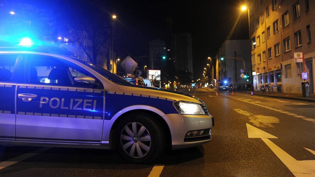 Ein Streifenwagen der Polizei ist abends auf einer Straße unterwegs.