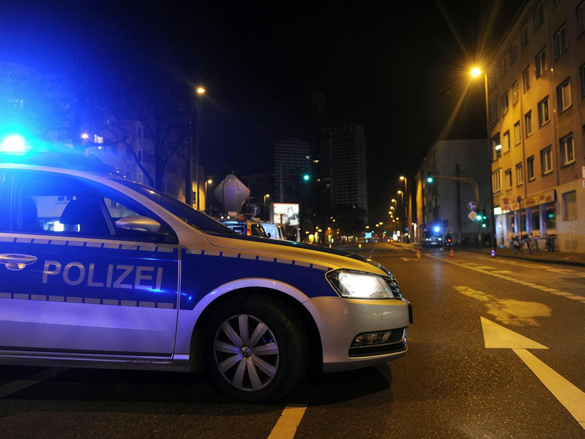 Ein Polizeiauto steht mit Blaulicht in Köln-Höhenhaus auf der Straße.