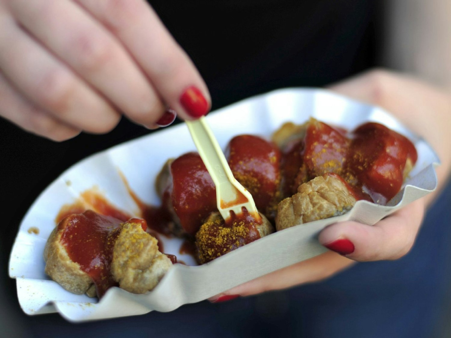 Currywurst auf einer Pappschale mit Plastikgabel