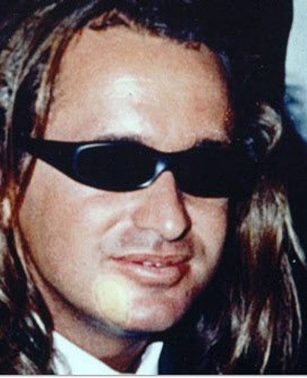 Ein Mann mit langen Haaren trägt eine Sonnenbrille.