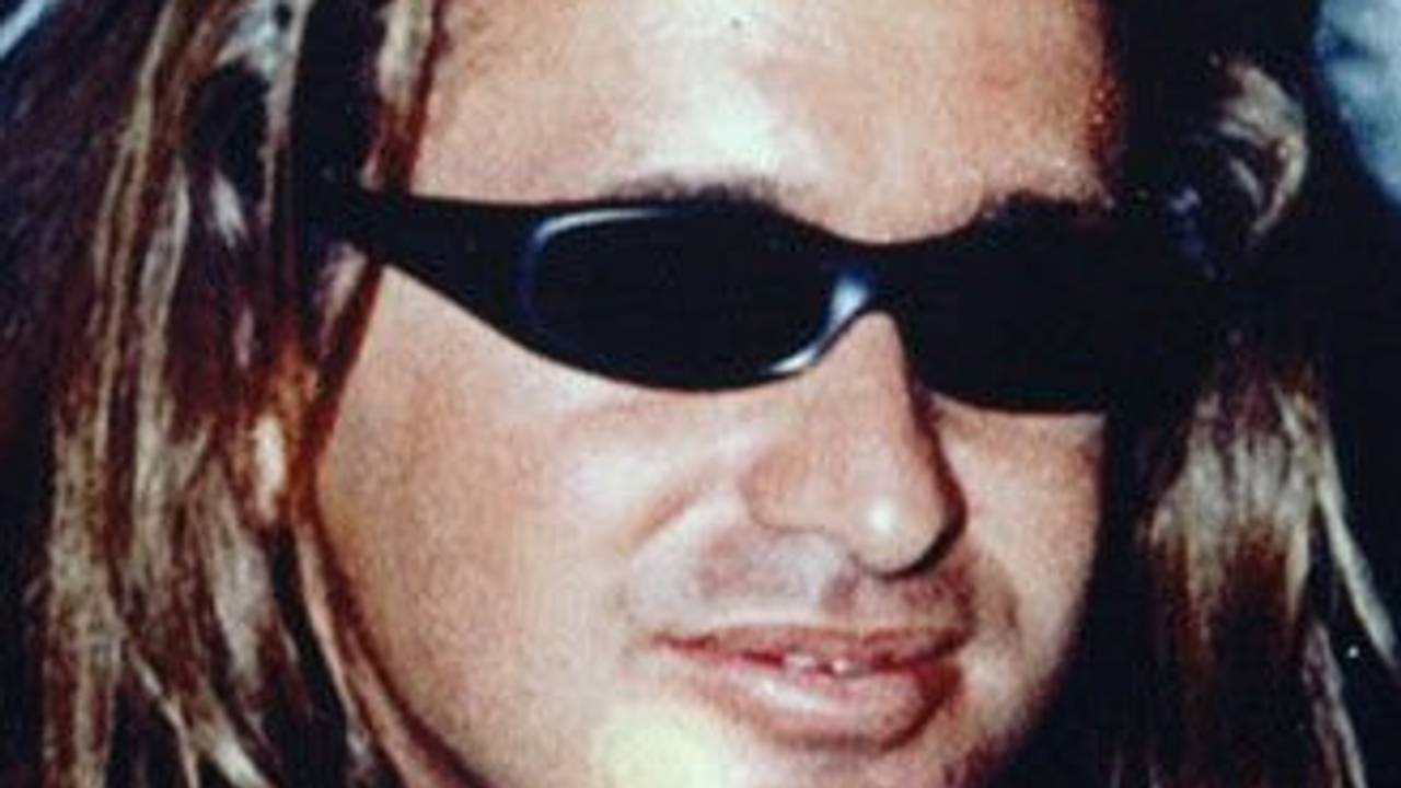 Ein Mann mit langen Haaren trägt eine Sonnenbrille.