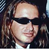 Ein Mann mit langen Haaren trägt eine Sonnenbrille.