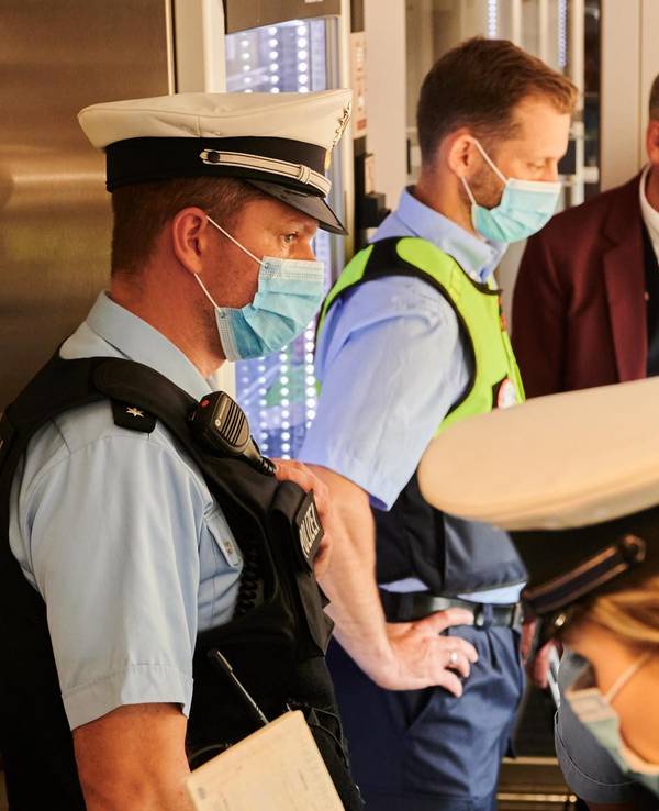 Eine Beamtin und zwei Beamte bei einer Kontrolle in der Bahn.