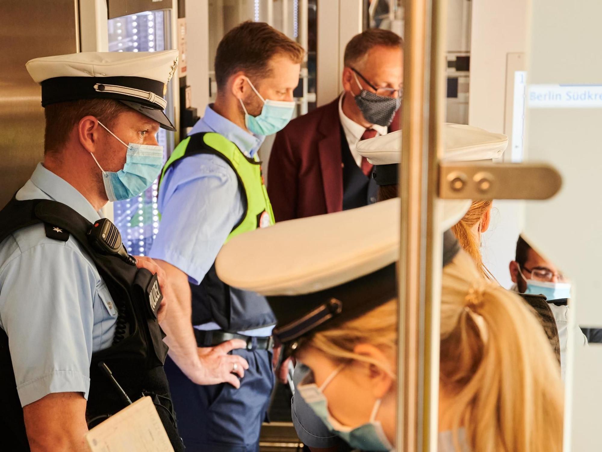 Eine Beamtin und zwei Beamte bei einer Kontrolle in der Bahn.