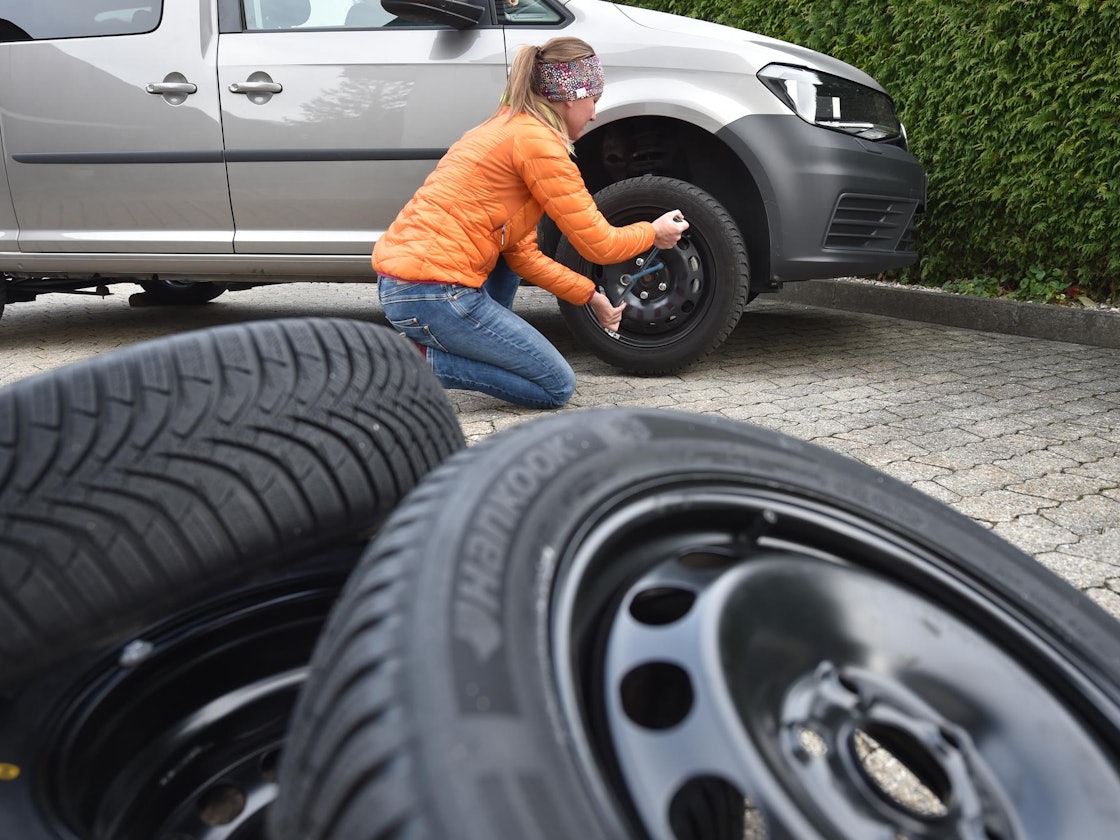 Eine Frau wechselt Reifen.