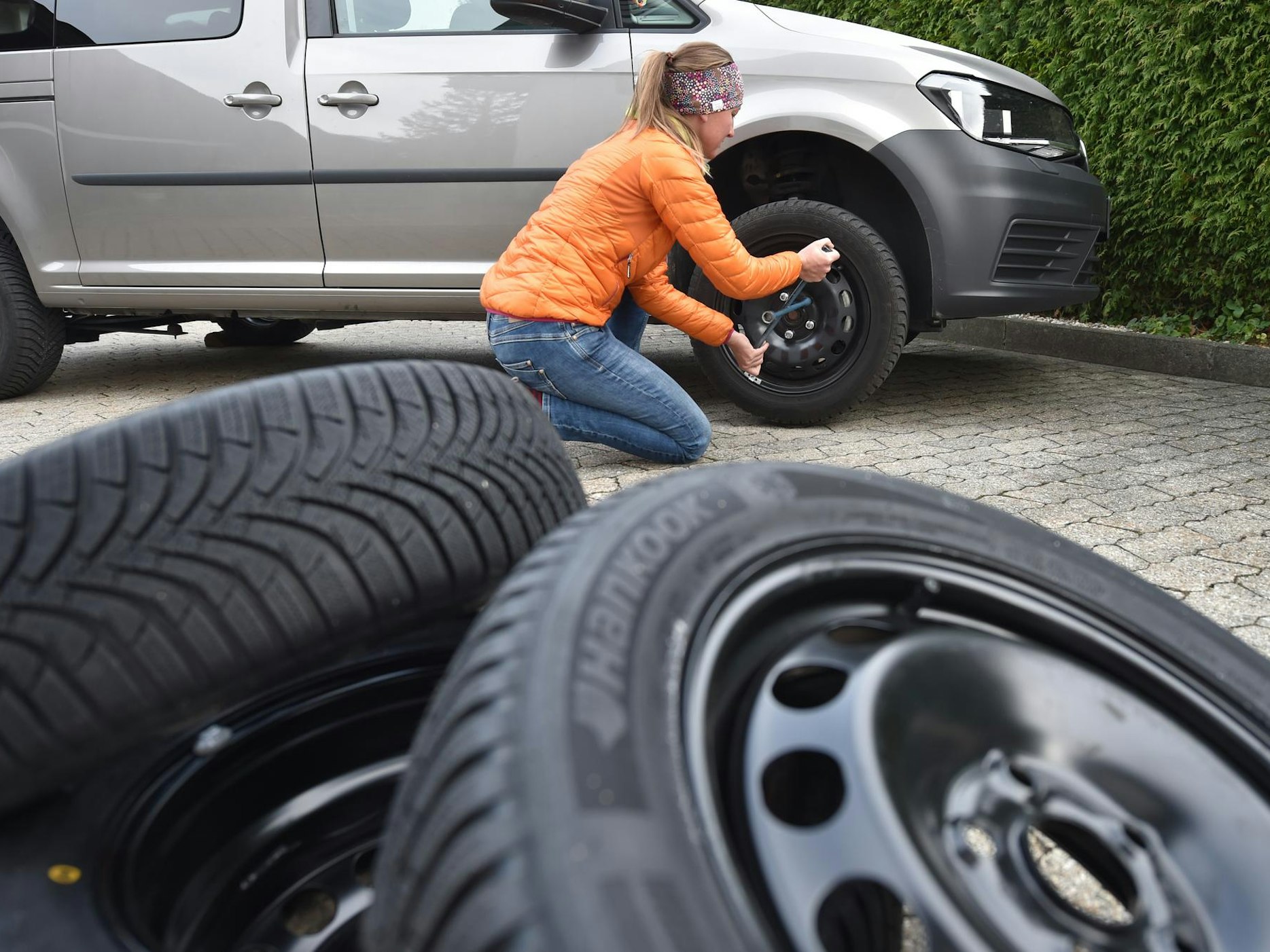 Eine Frau wechselt Reifen.