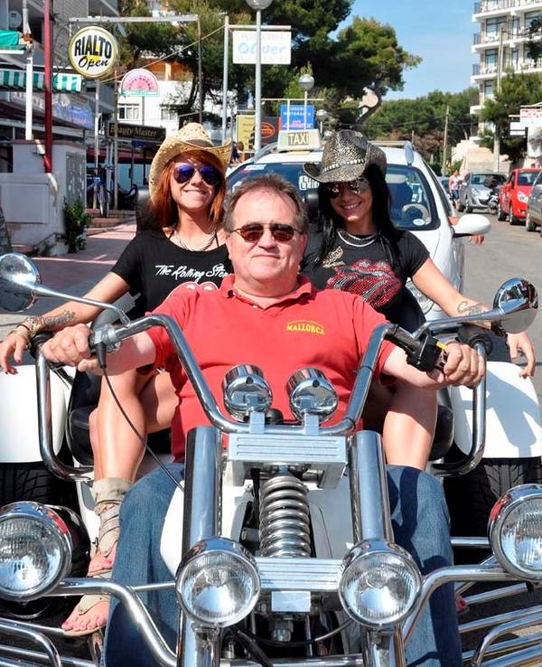 Michael Piontek sitzt mit zwei Frauen auf einem Motorrad.