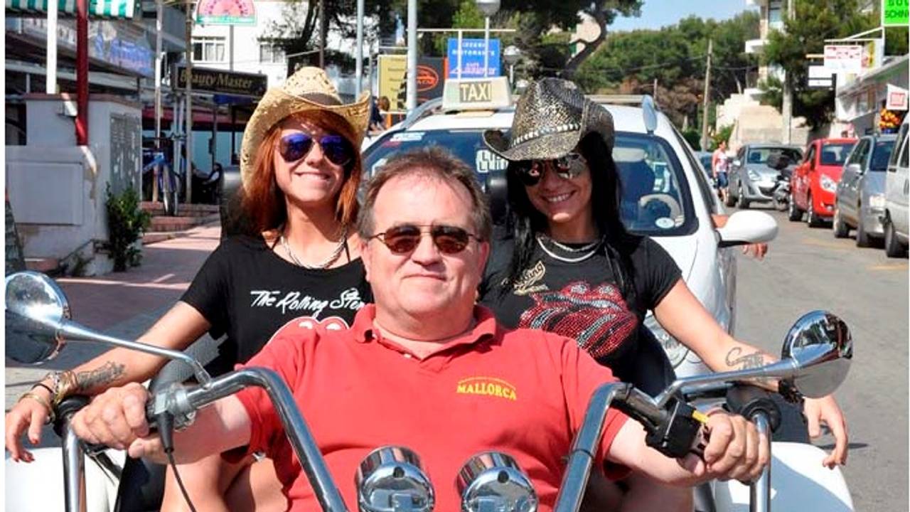 Michael Piontek sitzt mit zwei Frauen auf einem Motorrad.