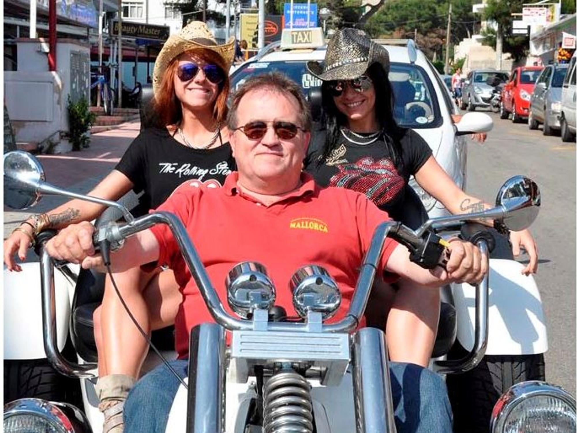 Michael Piontek sitzt mit zwei Frauen auf einem Motorrad.