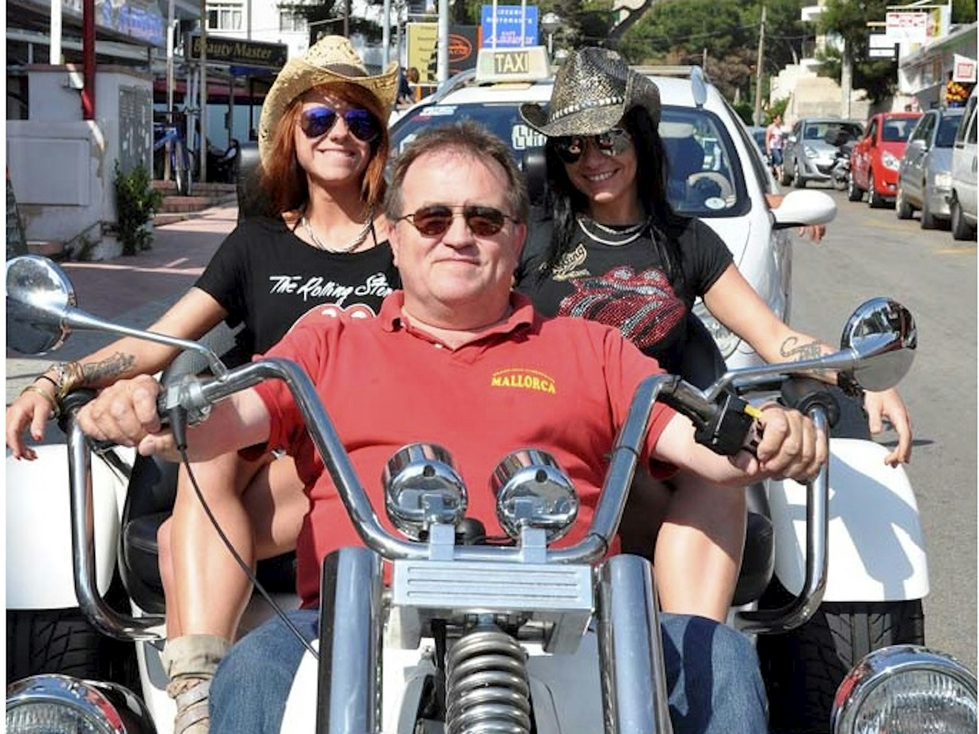 Michael Piontek sitzt mit zwei Frauen auf einem Motorrad.