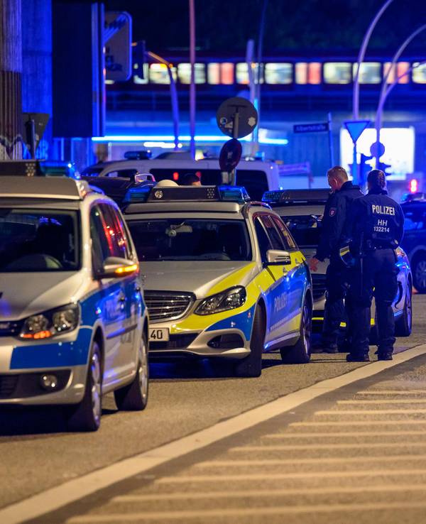 Einsatzwagen der Polizei stehen mit Blaulicht auf einer Straße.
