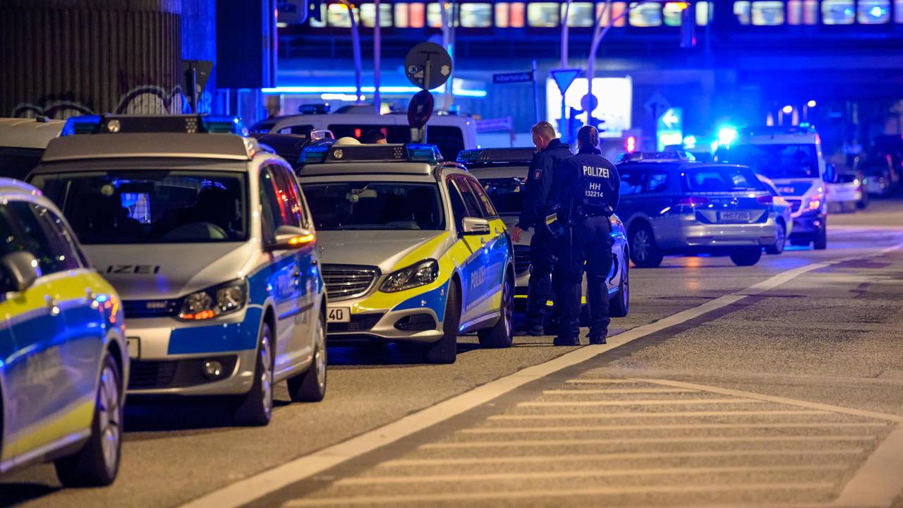 Einsatzwagen der Polizei stehen mit Blaulicht auf einer Straße.