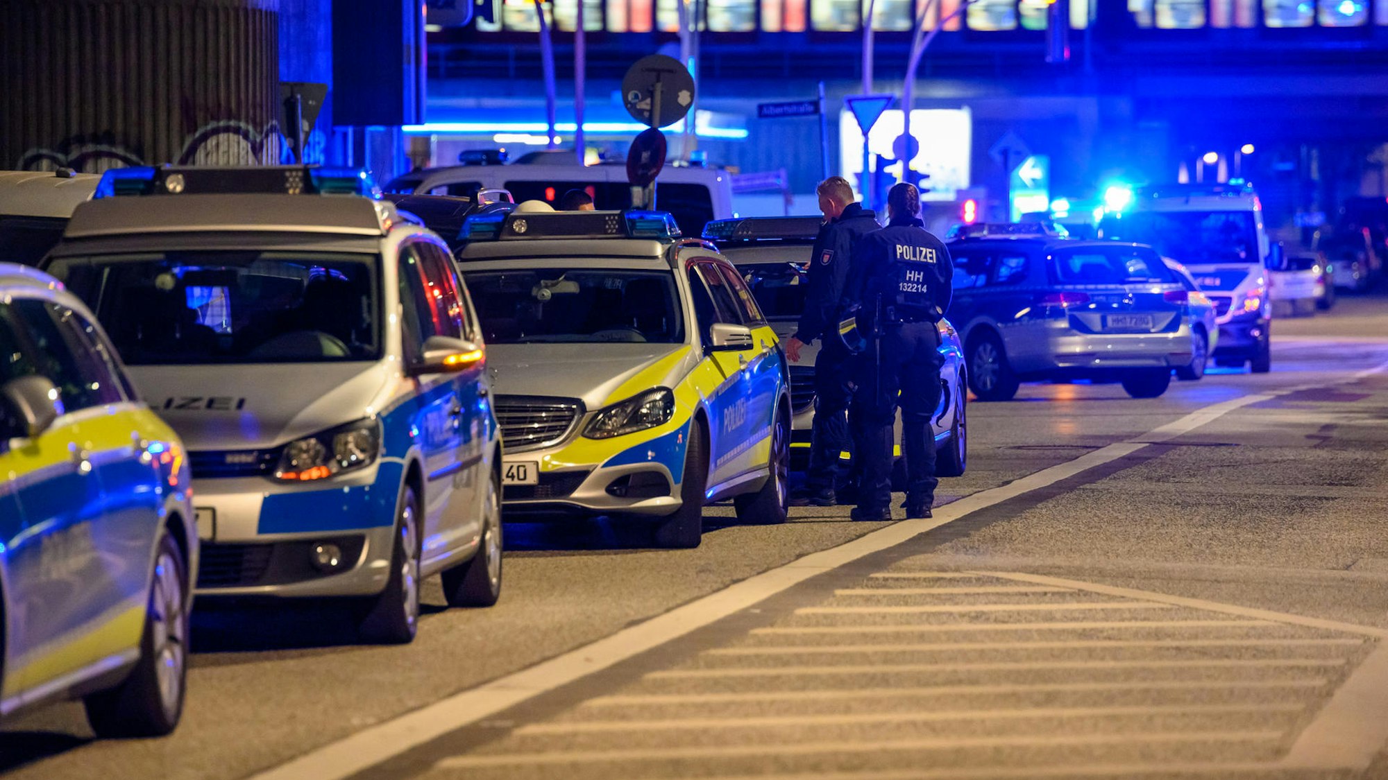 Einsatzwagen der Polizei stehen mit Blaulicht auf einer Straße.