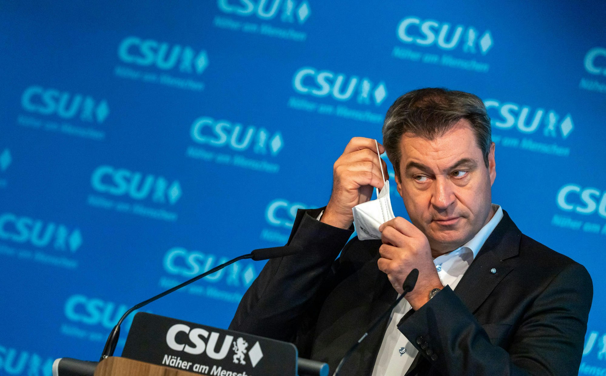 Markus Söder Maske am Ohr