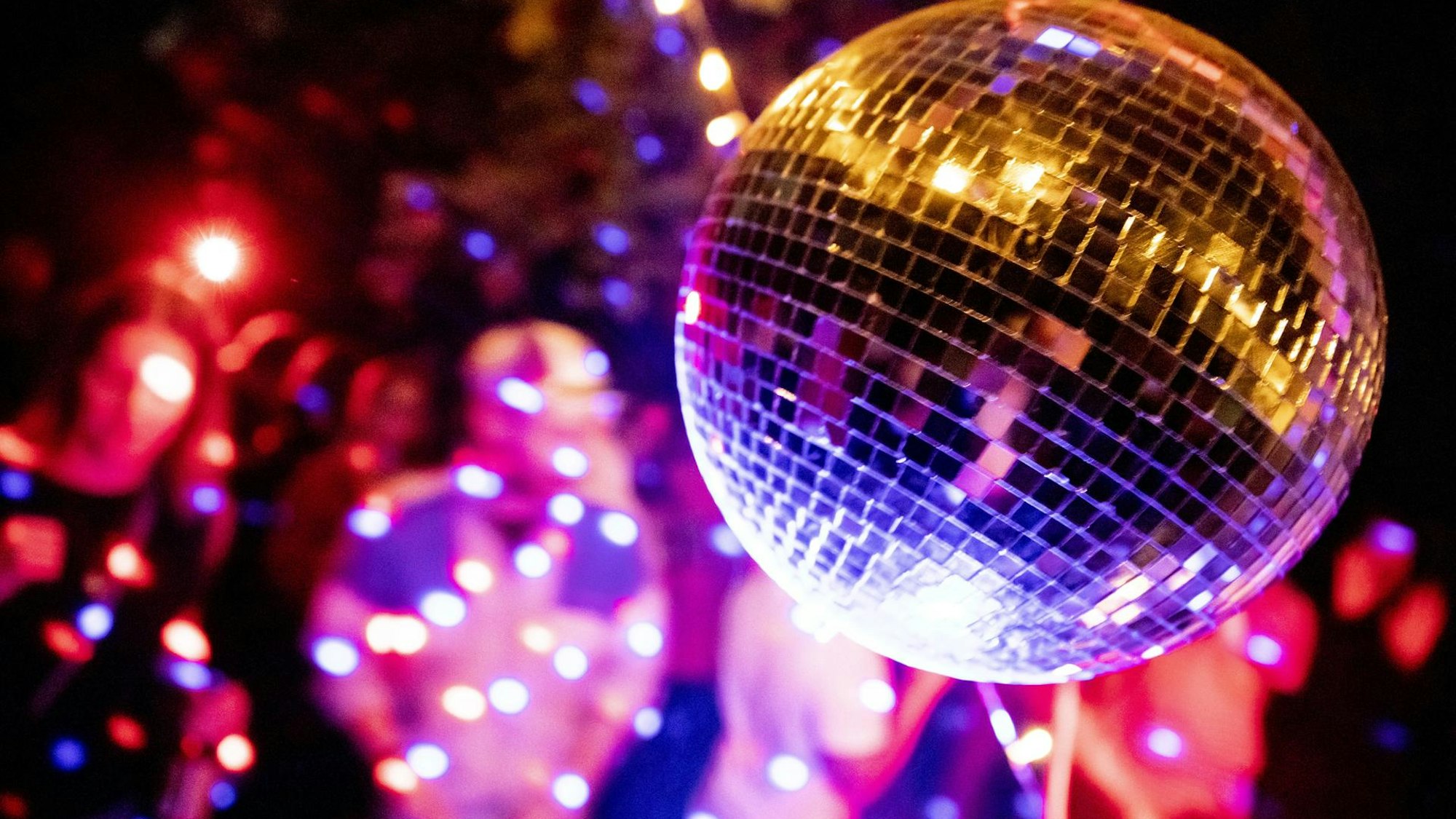Eine Diskokugel dreht sich bei einer Party.