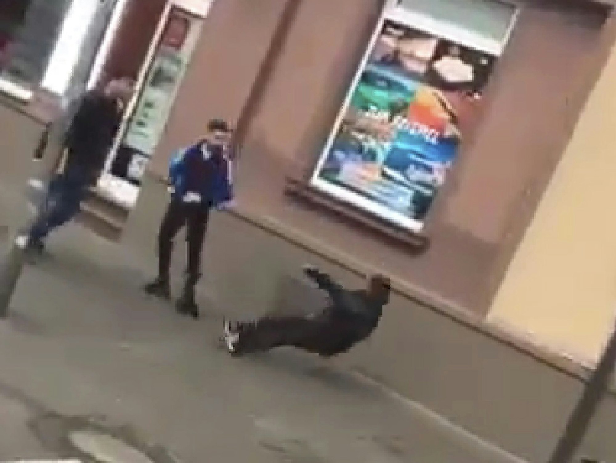 Ein Obdachloser kippt nach hinten, nachdem er von einem der beiden Jugendlichen getreten worden war.