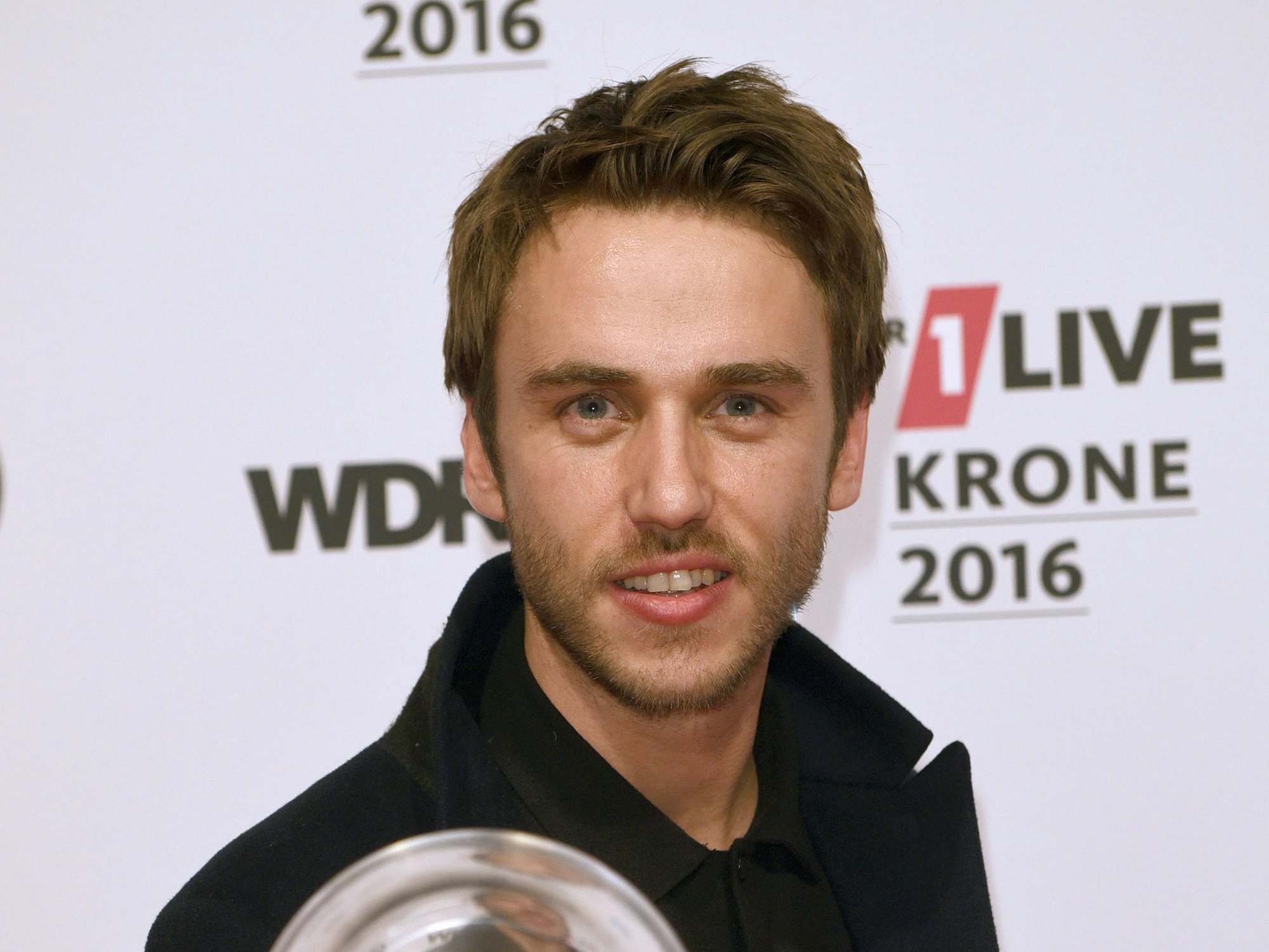 Clueso zeigt stolz die Eins-Live-Krone, die er 2016 gewonnen hat.
