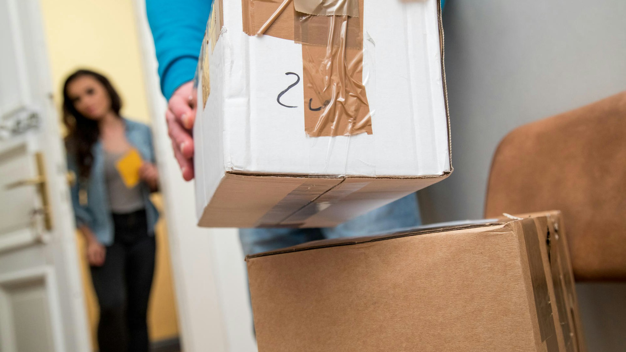 Kartons werden in einen Raum getragen.