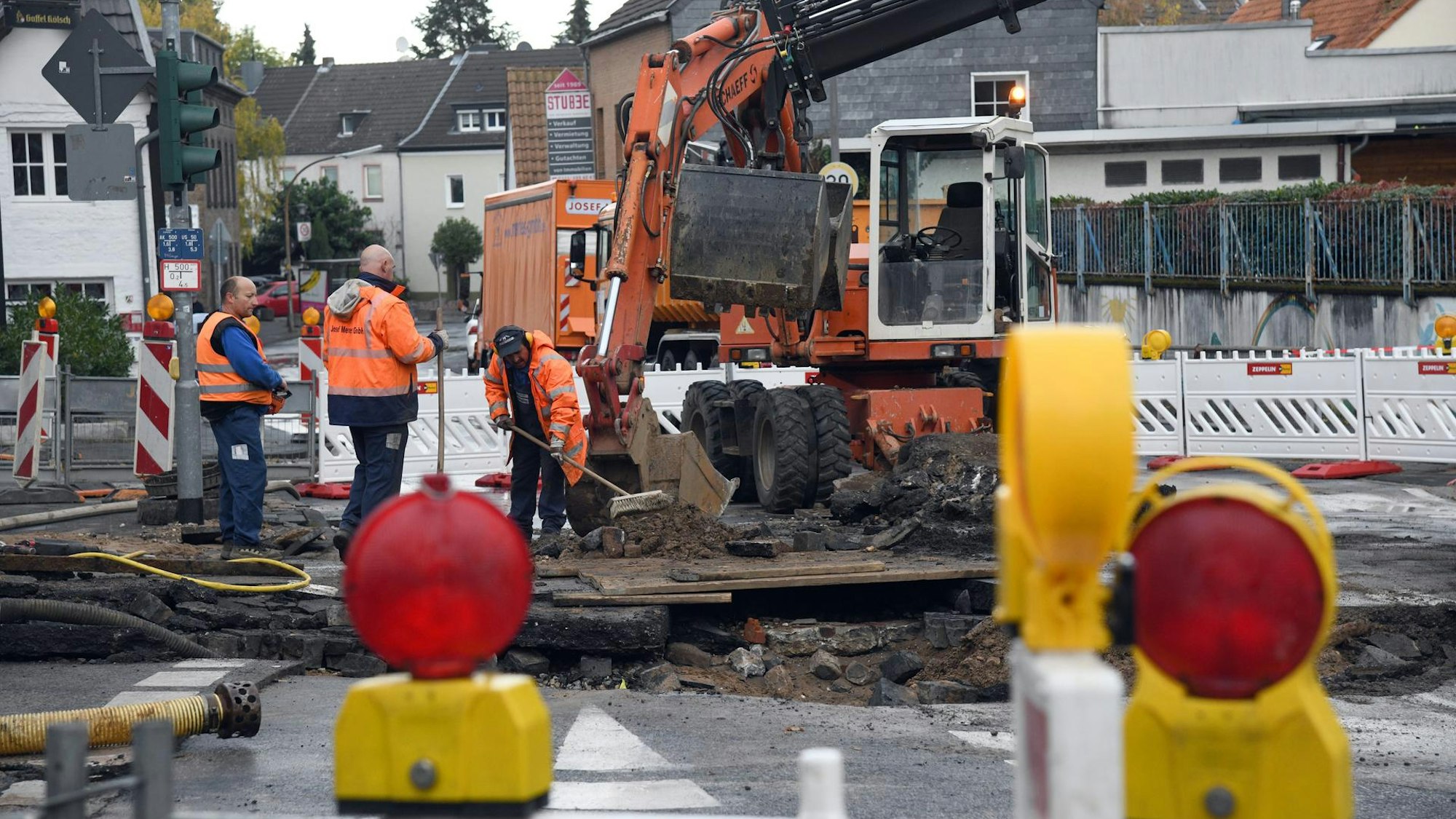 Bauarbeiter und ein Bagger an einer Baustelle nach einem Rohbruch in Köln.