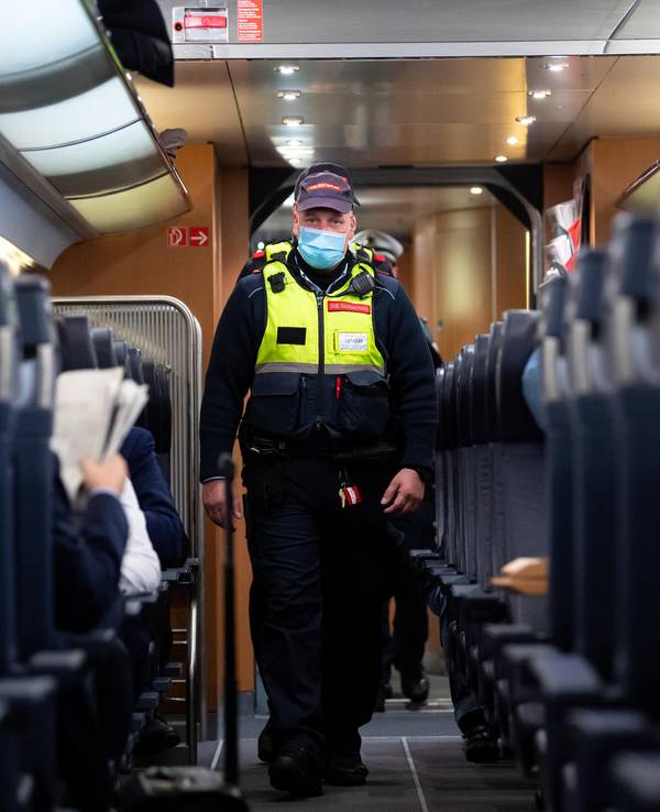 Das undatierte Symbolfoto zeigt einen Polizisten, der durch einen Zug läuft.