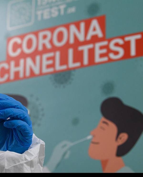 Mitarbeiterin in Schutzanzug bereitet Corona-Test vor