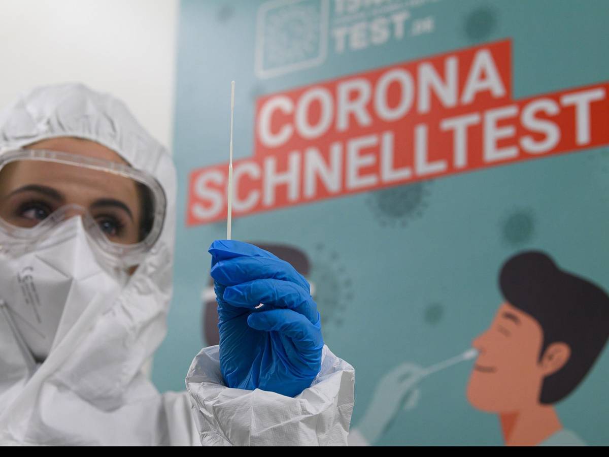 Mitarbeiterin in Schutzanzug bereitet Corona-Test vor
