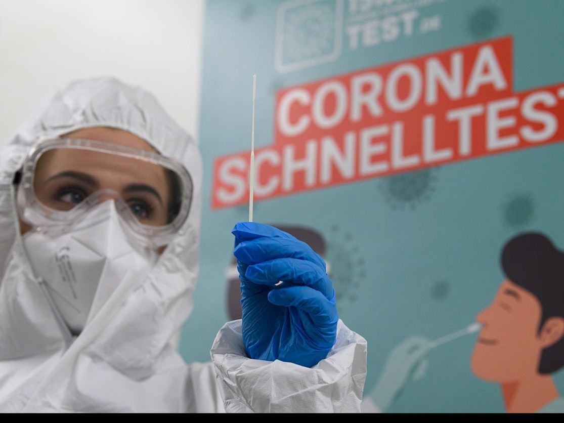 Mitarbeiterin in Schutzanzug bereitet Corona-Test vor