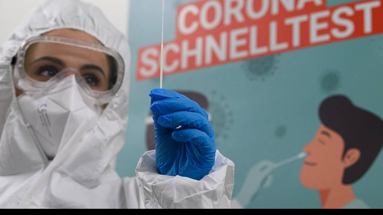 Mitarbeiterin in Schutzanzug bereitet Corona-Test vor