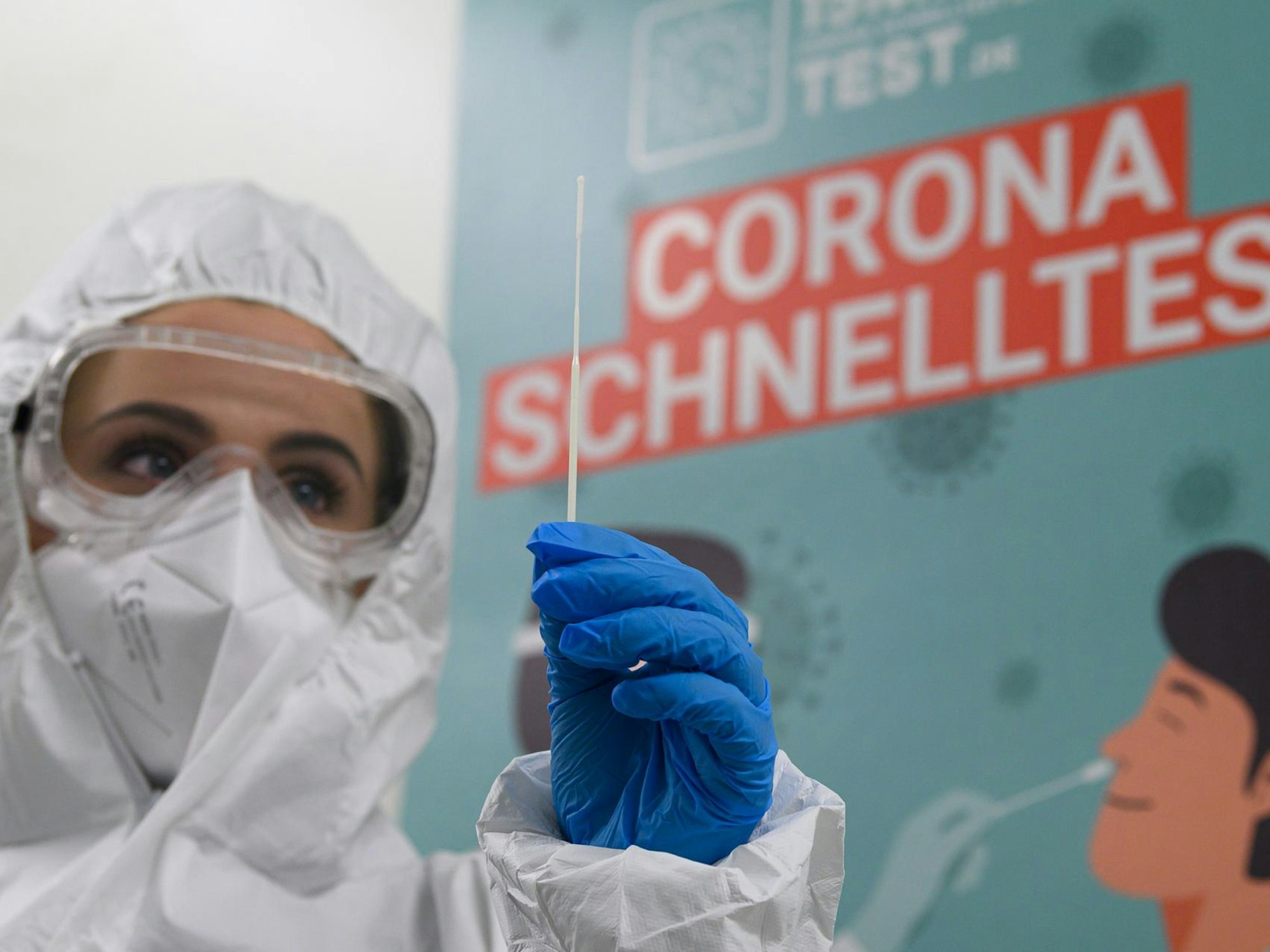 Eine Mitarbeiterin in Schutzanzug bereitet einen Corona-Test vor.