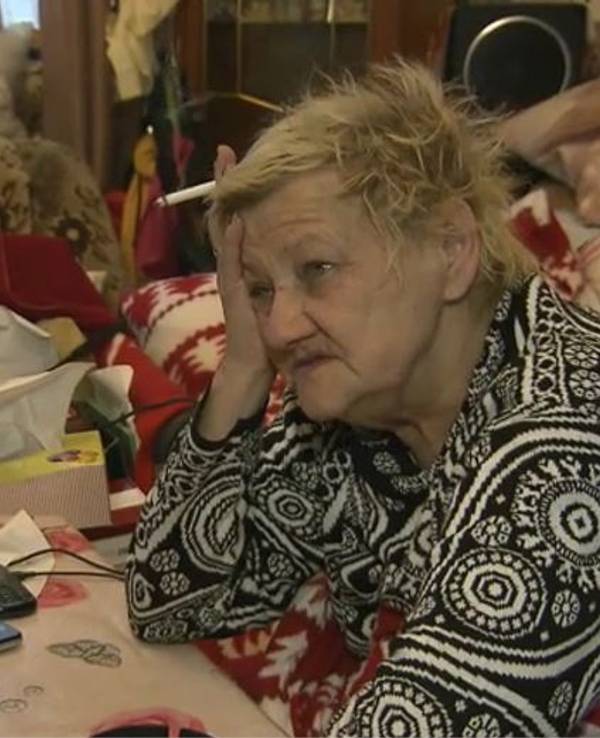 Karin Ritter (verstorben im Januar 2021) sitzt 2018 in eine Decke gehüllt an einem überfüllten Tisch.