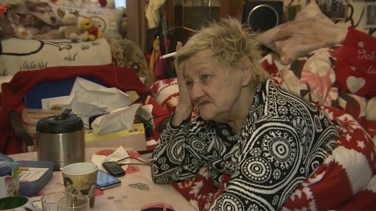 Karin Ritter (verstorben im Januar 2021) sitzt 2018 in eine Decke gehüllt an einem überfüllten Tisch.