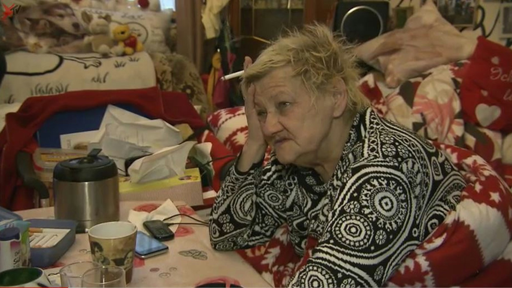 Karin Ritter (verstorben im Januar 2021) sitzt 2018 in eine Decke gehüllt an einem überfüllten Tisch.