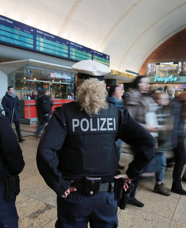 Polizistinnen kontrollieren im Kölner Hauptbahnhof Menschen.