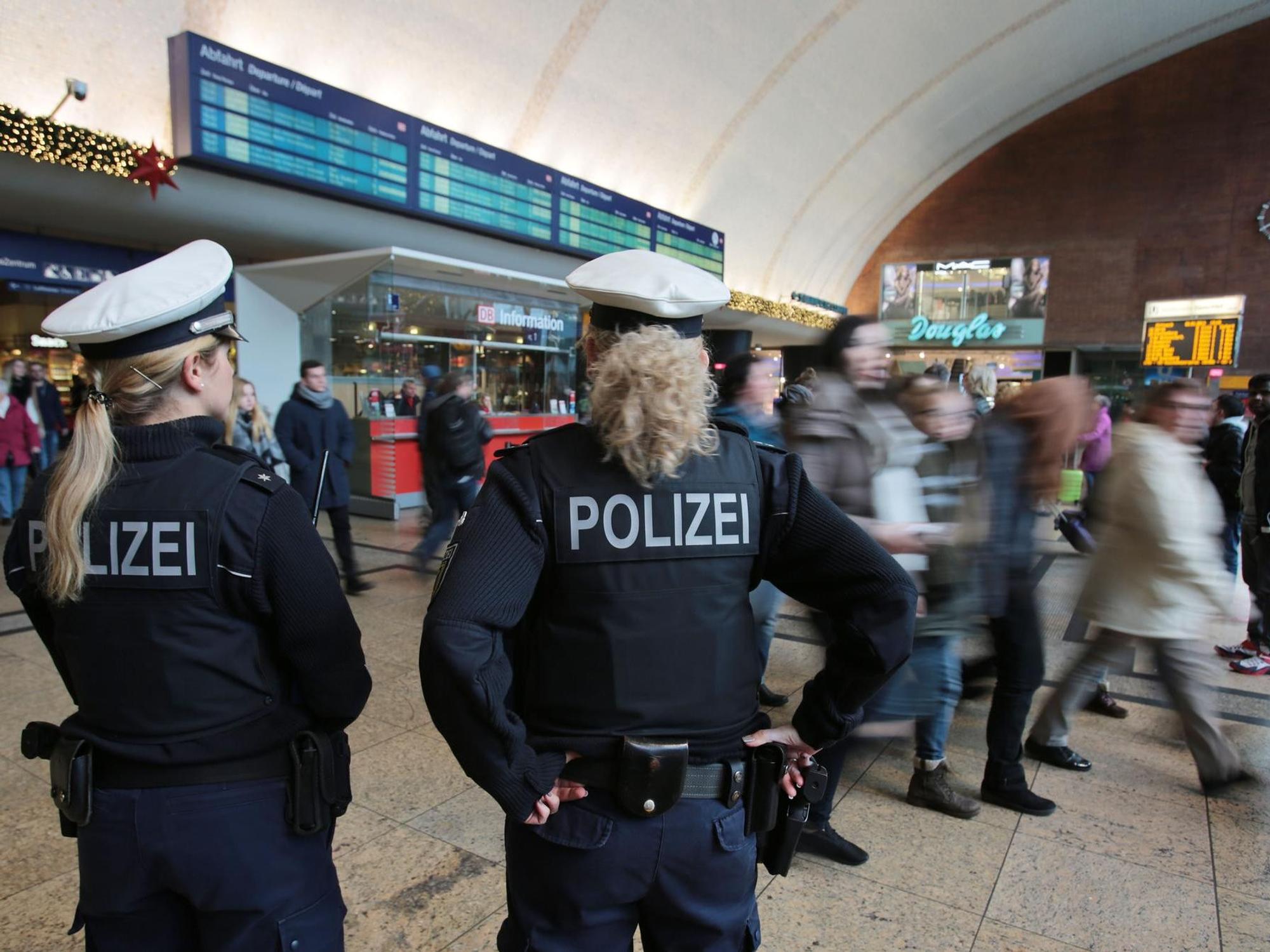 Polizistinnen kontrollieren im Kölner Hauptbahnhof Menschen.
