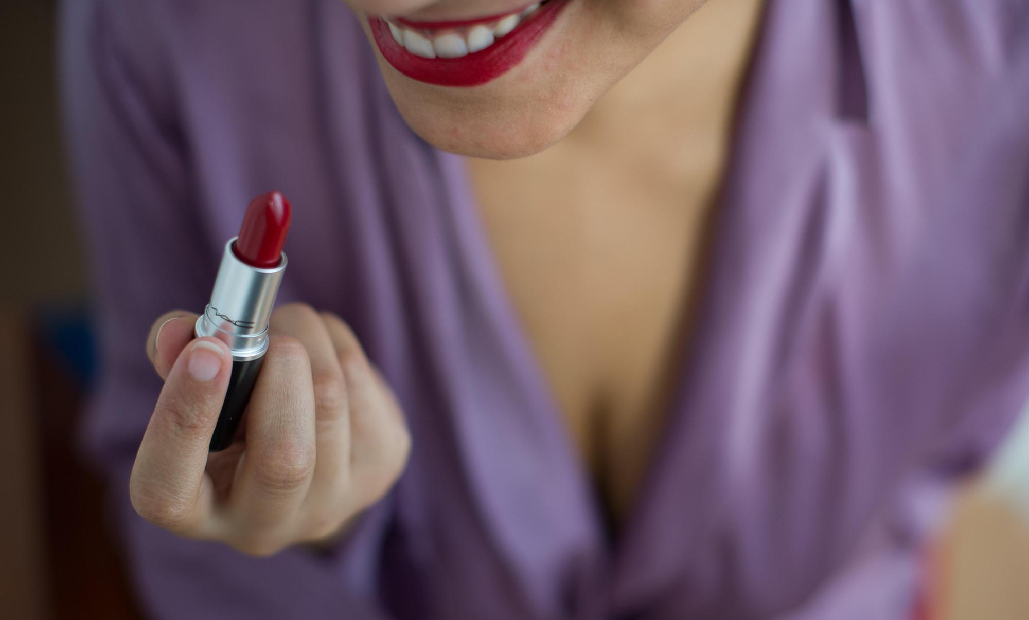 Eine Frau hält einen Lippenstift in der Hand.