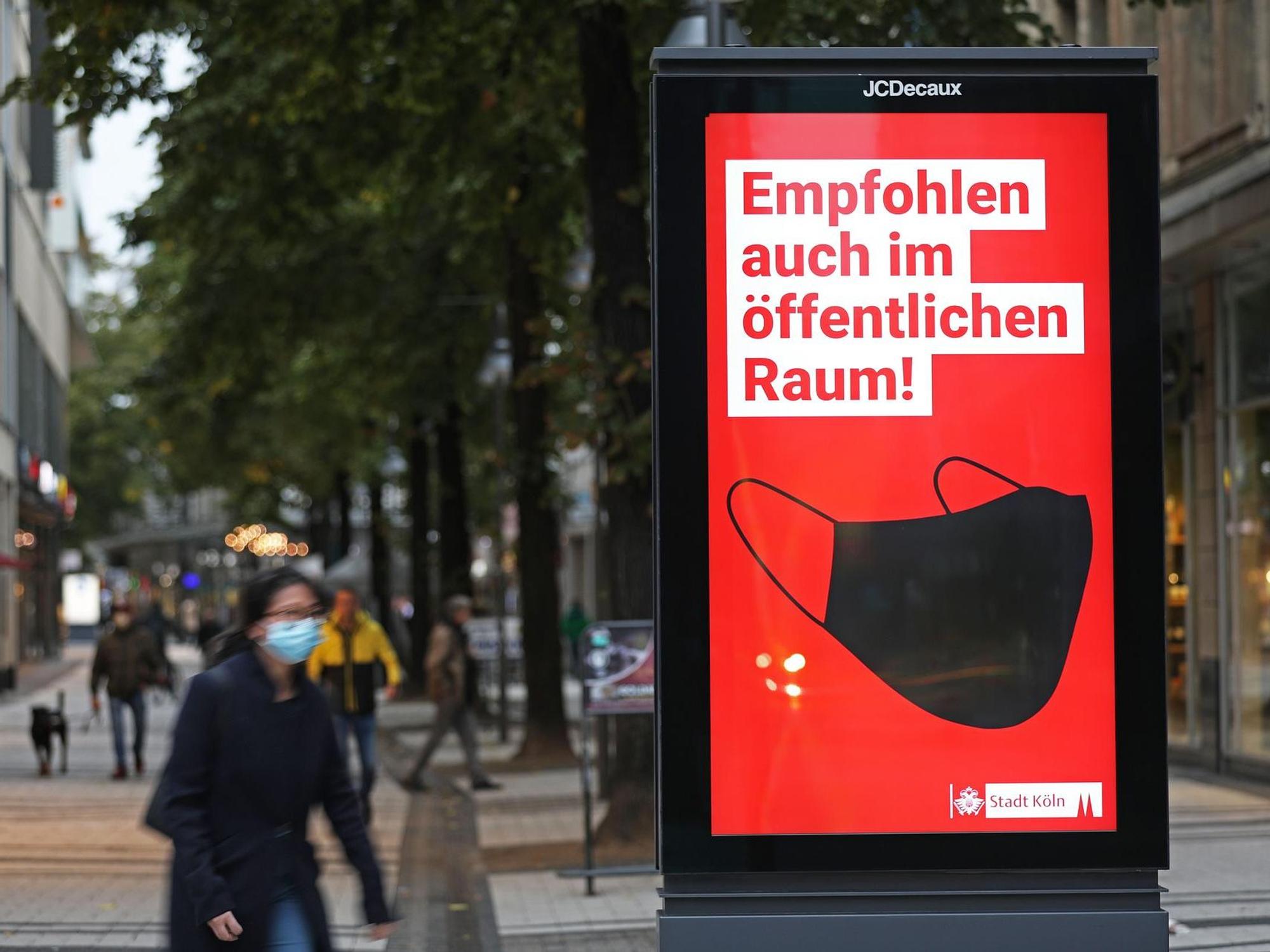 Werbetafel wirbt für das Tragen von Schutzmasken im öffentlichen Raum. In Deutschland ist die bundesweite Corona-Inzidenz wieder deutlich angestiegen.