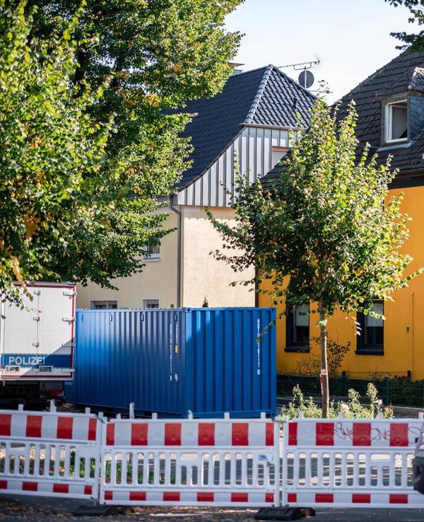 Polizeiauto vor einem Haus bei einem Einsatz.