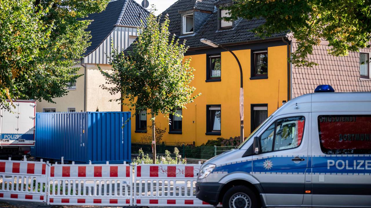 Polizeiauto vor einem Haus bei einem Einsatz.