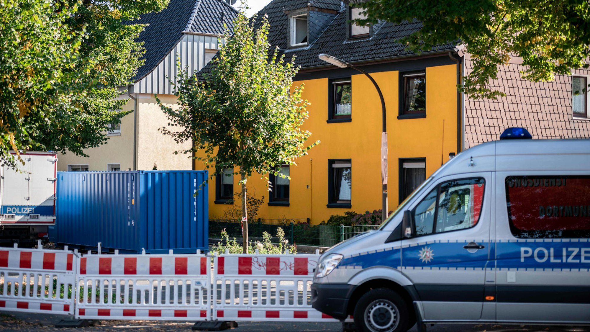 Polizeiauto vor einem Haus bei einem Einsatz.