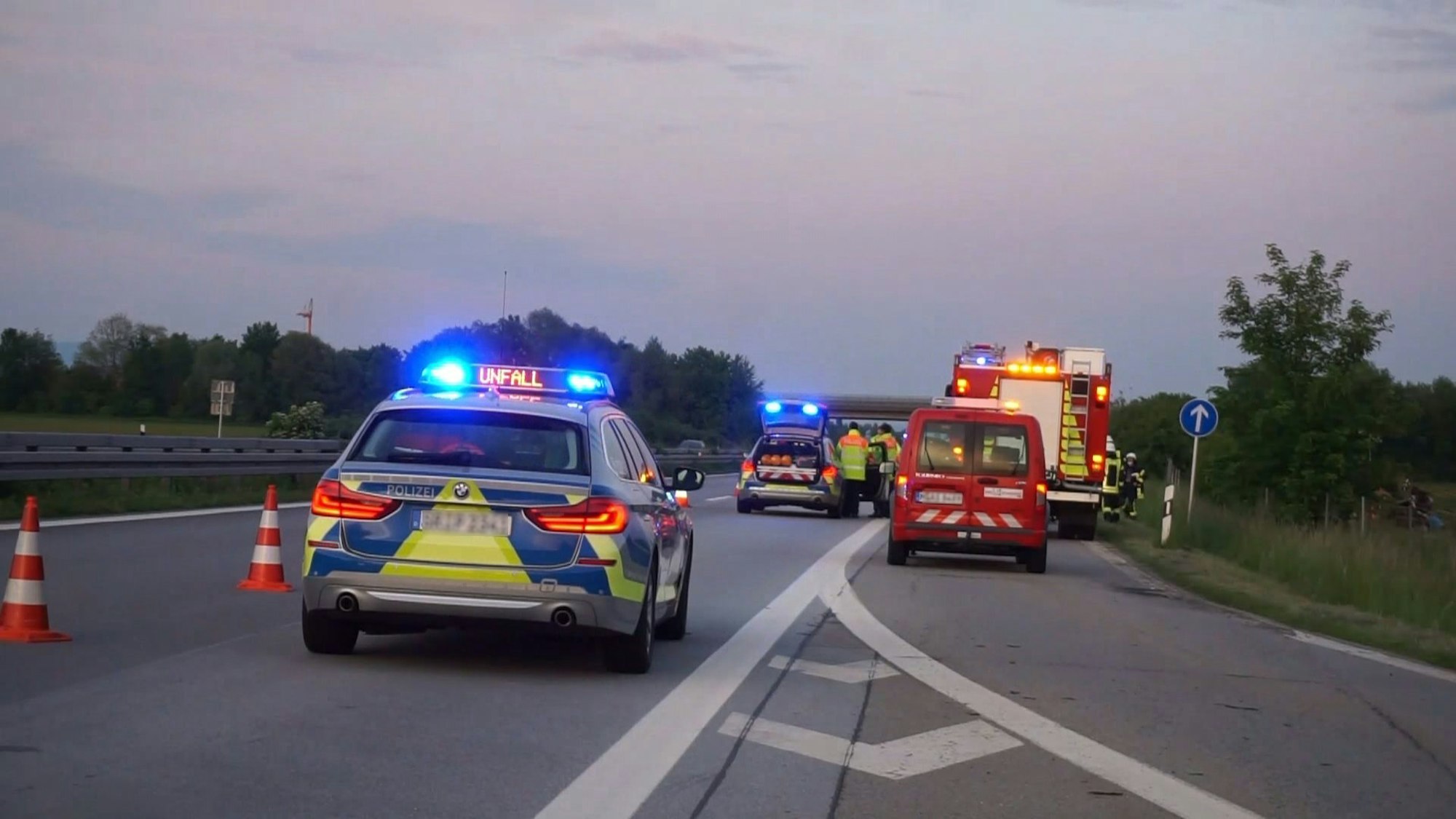 Polizei- und Feuerwehrfahrzeuge stehen auf einer Autobahn.