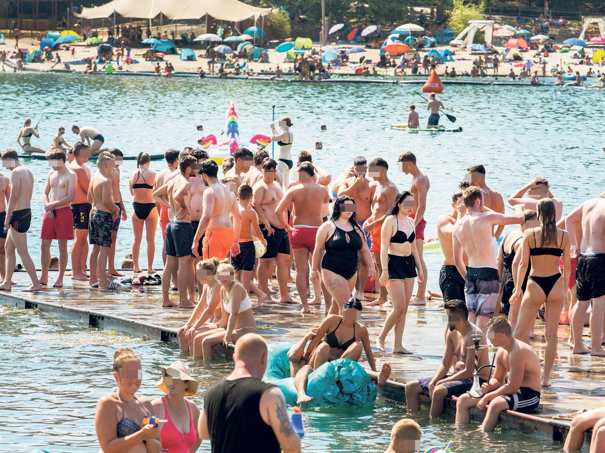 Badegäste stehen auf einem Steg am Fühlinger See in Köln.