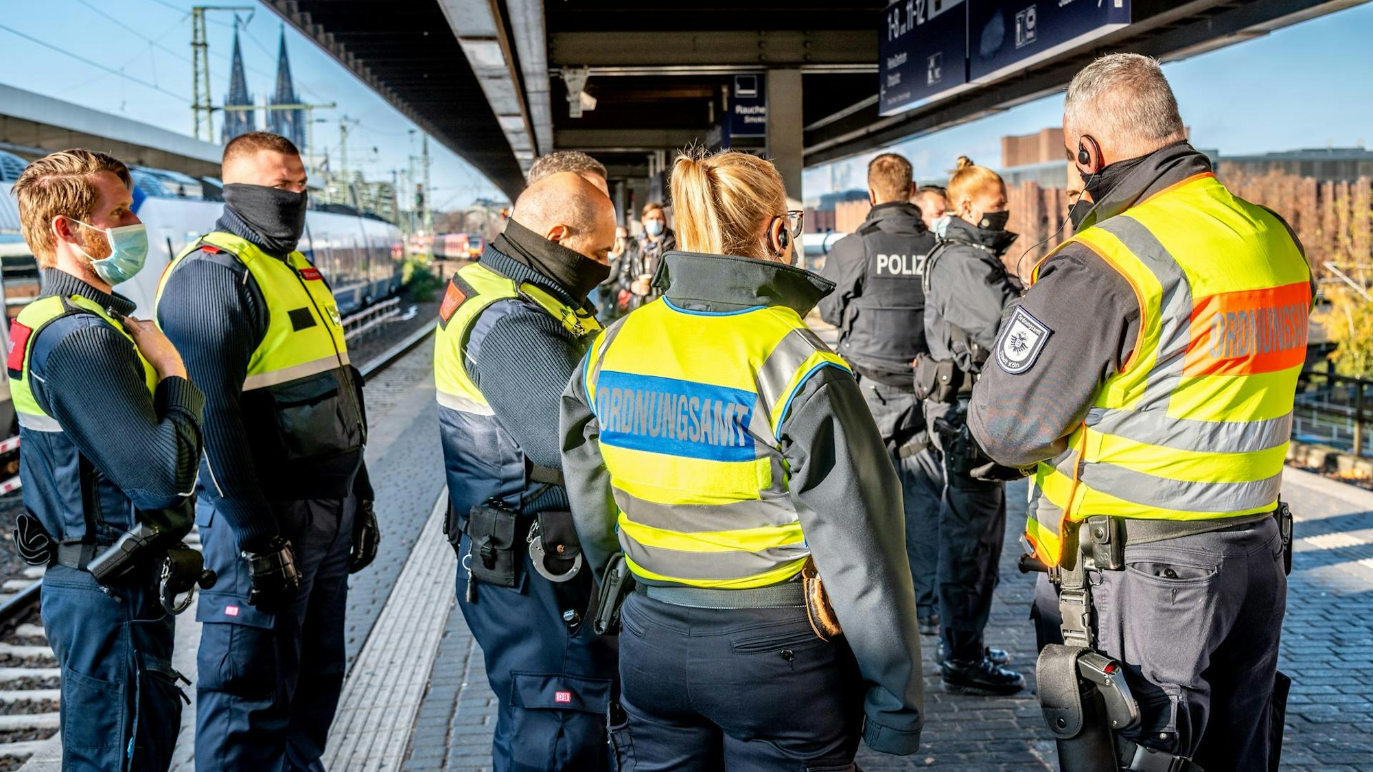 Kräfte von Polizei und Ordnungsamt stehen auf einem Bahnsteig.