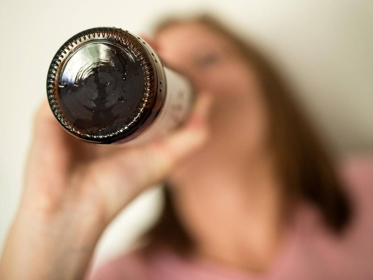 Eine Frau trinkt aus einer Flasche.