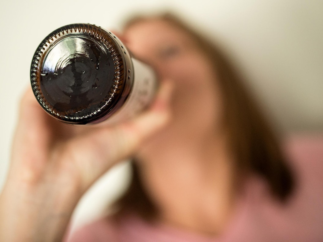 Eine Frau trinkt aus einer Flasche.