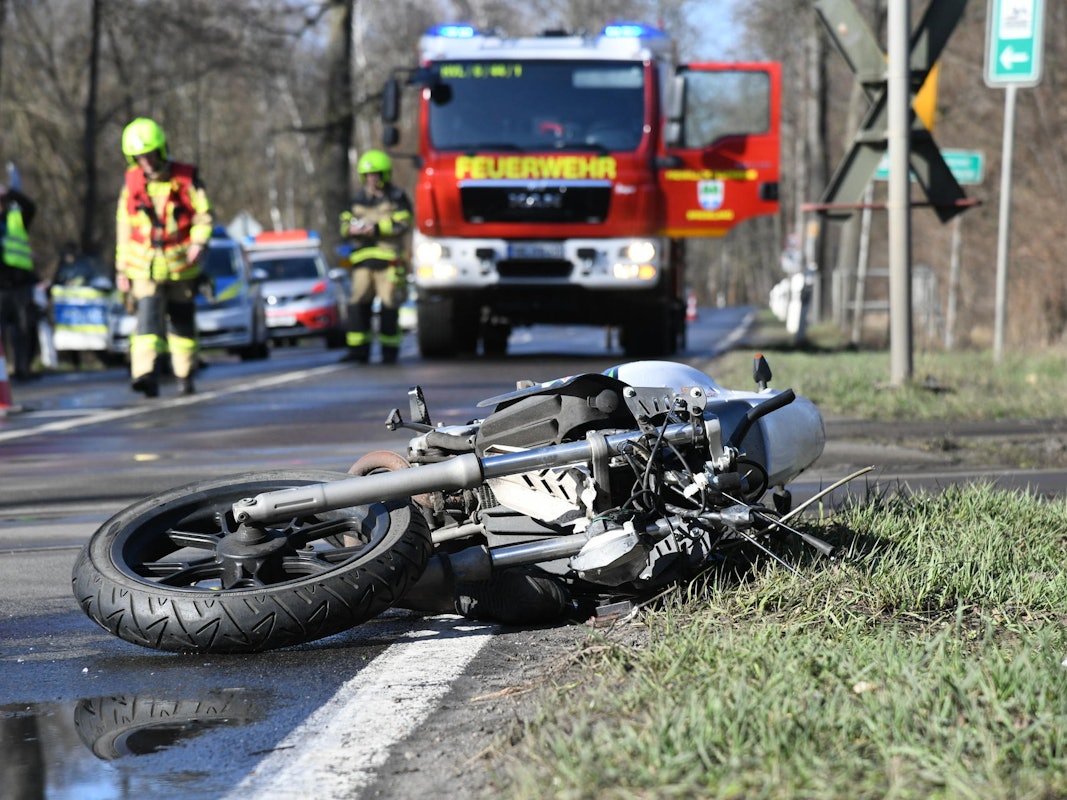 Ein stark beschädigtes Motorrad liegt auf einer Landstraße.