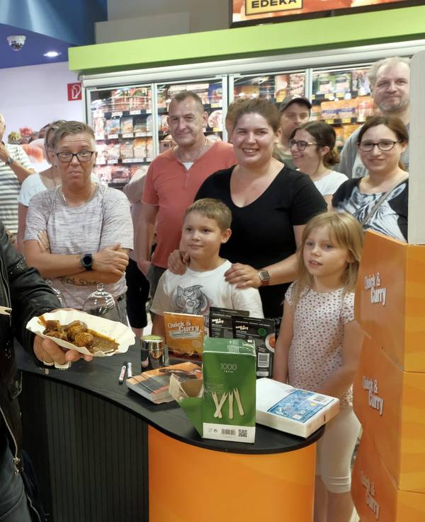 Chris Töpperwien verteilt Currywurst in einem Kölner Supermarkt.