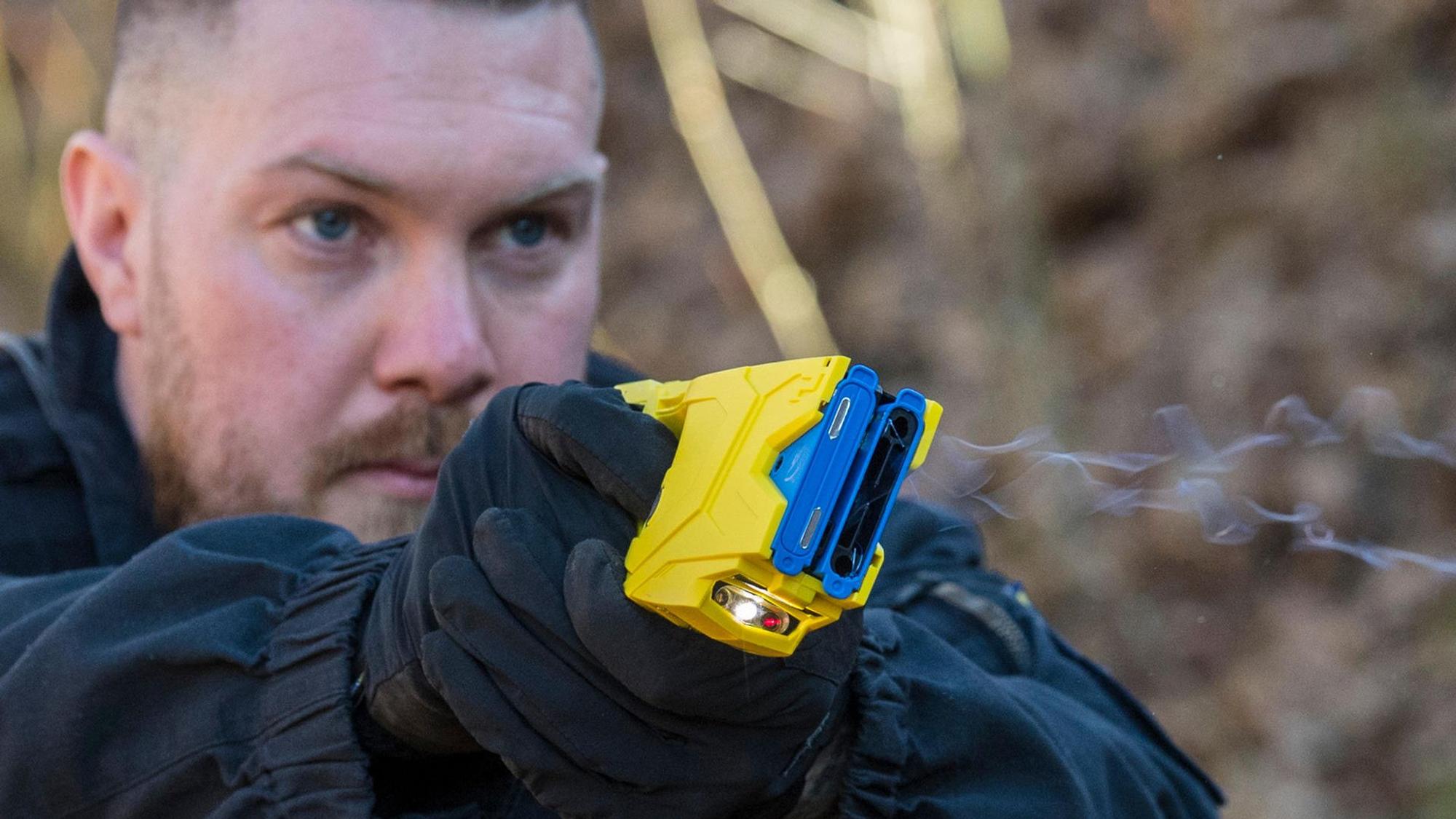Ein Polizist feuert einen Taser ab.