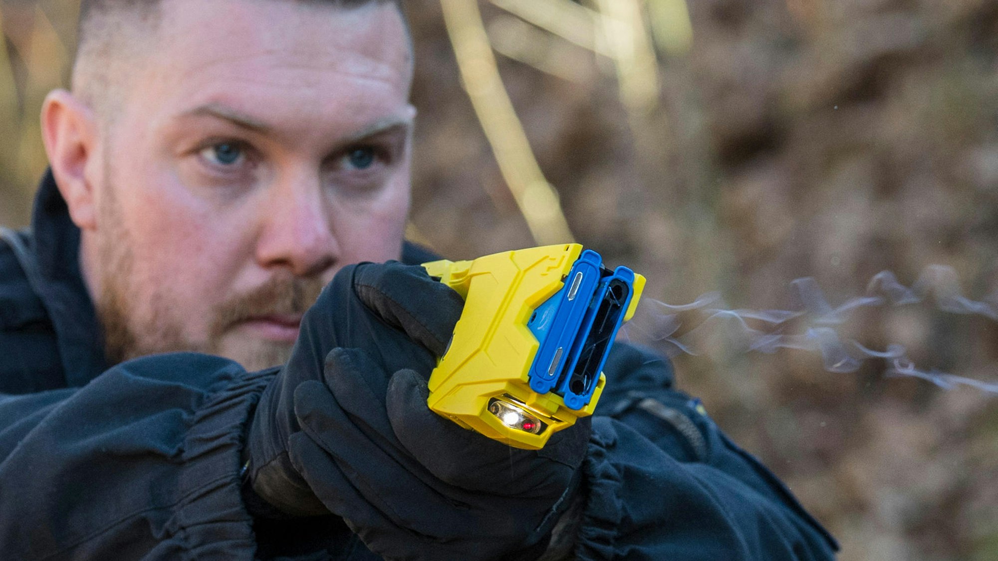 Ein Polizist feuert einen Taser ab.