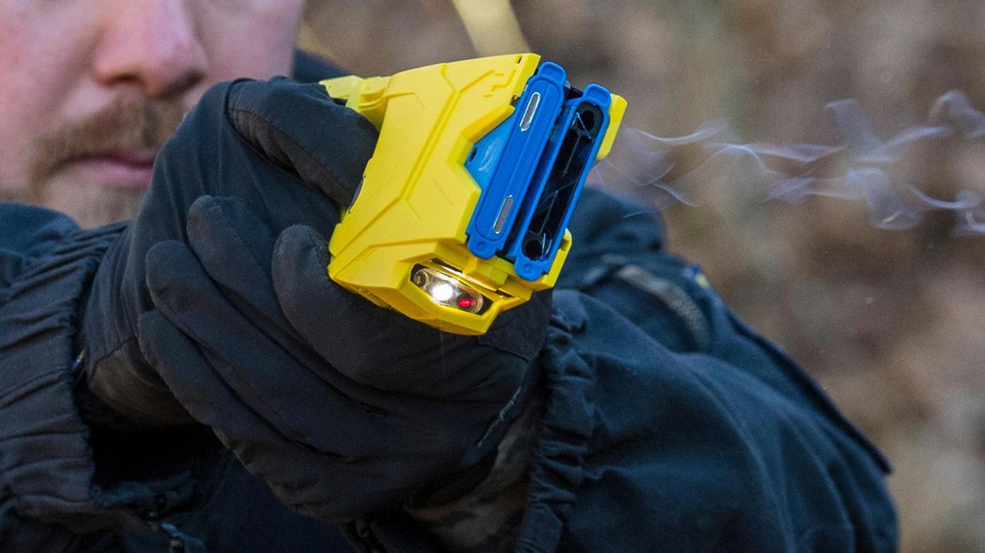 Ein Polizist hält einen Elektroschocker.