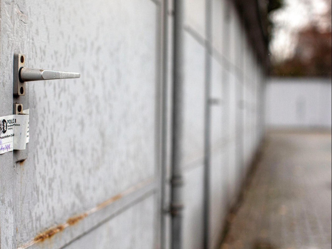 Eine Garagentür ist mit einem Polizeisiegel versehen.